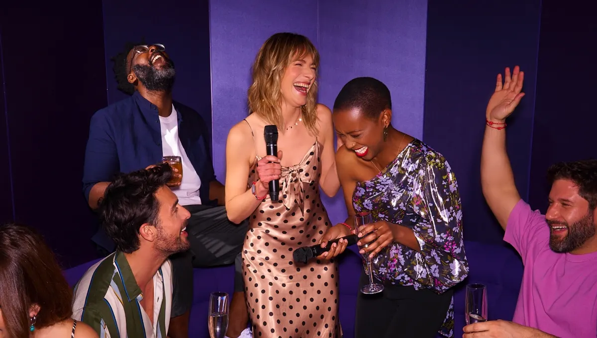 Friends singing karaoke in a private room on a Virgin Voyages ship